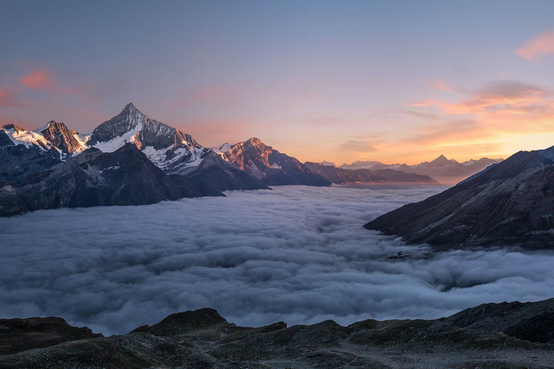 Alpine peaks standing above a sea of clouds.